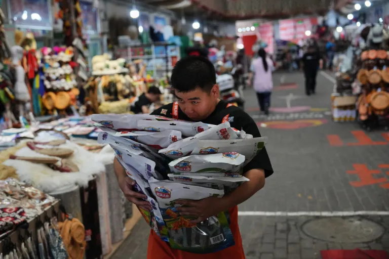 A worker carries packaging of local specialty products at Jinshan market in Altay prefecture, in the northwest Xinjiang Uyghur Autonomous Region of China