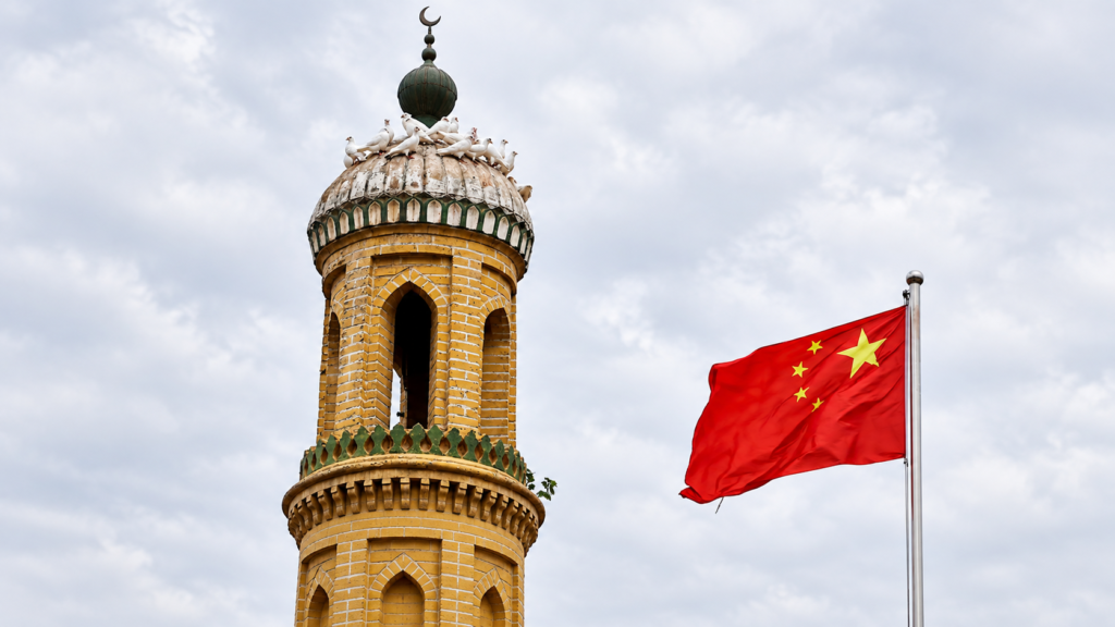A Chinese national flag flutters near a minaret of the ancient Id Kah Mosque in the Old City in Kashgar in Xinjiang Uyghur Autonomous Region